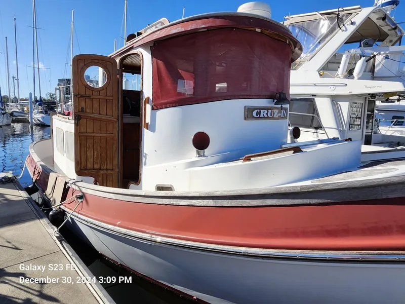 Slide: The Image of 1988 Lord Nelson Victory 37 boat docked at marina, featuring wooden cabin and red accents. - 4