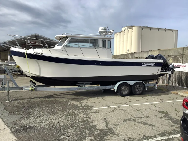 Slide: The Image of 2018 Osprey 26 Long Cabin boat on trailer in parking lot. - 1