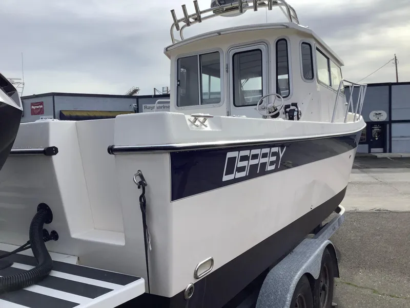Slide: The Image of 2018 Osprey 26 Long Cabin boat on trailer, docked outdoors. - 4