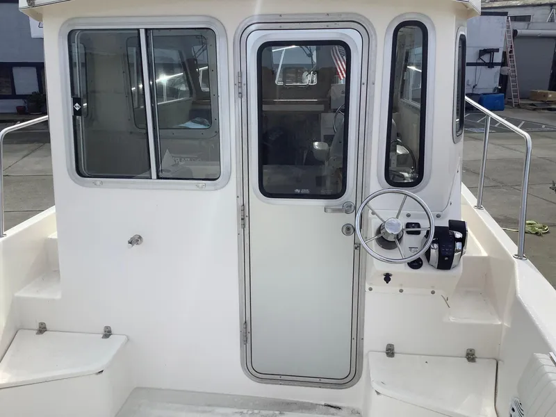 Slide: The Image of 2018 Osprey 26 Long Cabin boat with white exterior and enclosed cabin. - 7