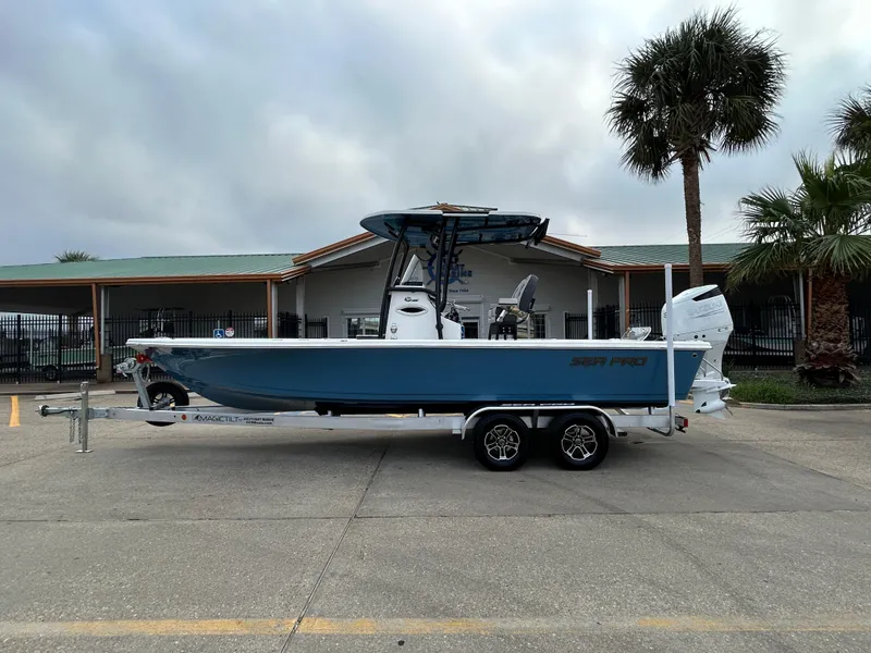 The Image of 2024 Sea Pro 250 DLX boat on trailer, parked near palm trees. - 0