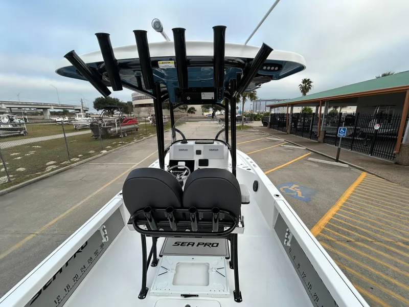 Slide: The Image of 2024 Sea Pro 250 DLX boat interior with seating and rod holders. - 13