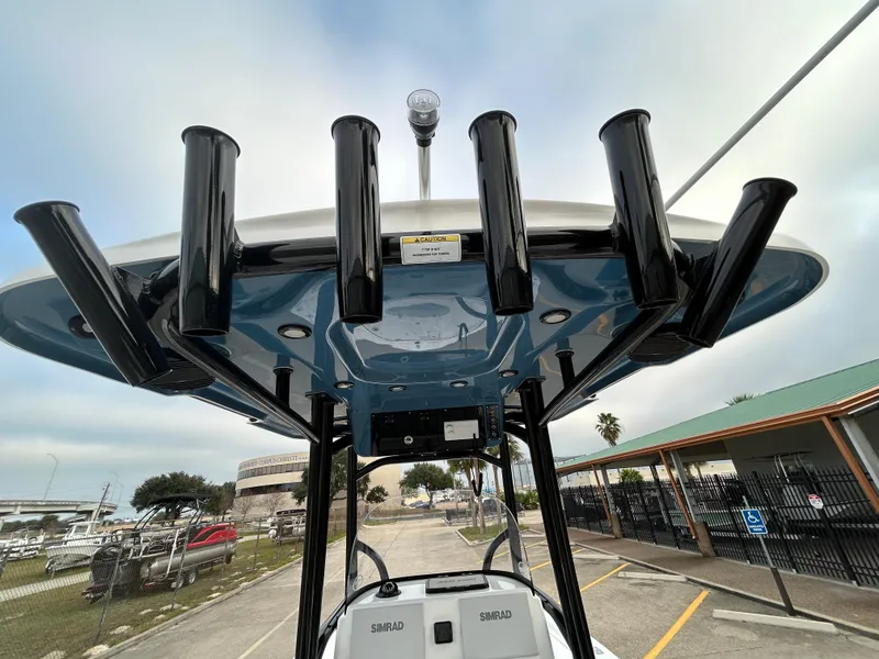 Slide: The Image of 2024 Sea Pro 250 DLX boat with rod holders and T-top, docked in a marina. - 14