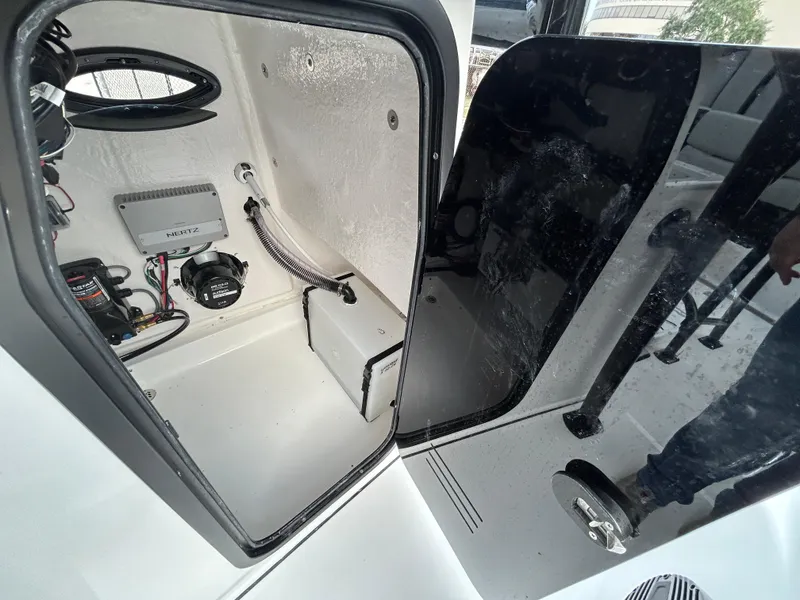 Slide: The Image of 2024 Sea Pro 250 DLX boat interior with open storage compartment and visible wiring. - 18