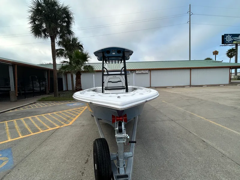 Slide: The Image of 2024 Sea Pro 250 DLX boat on trailer in parking lot, palm trees in background. - 2