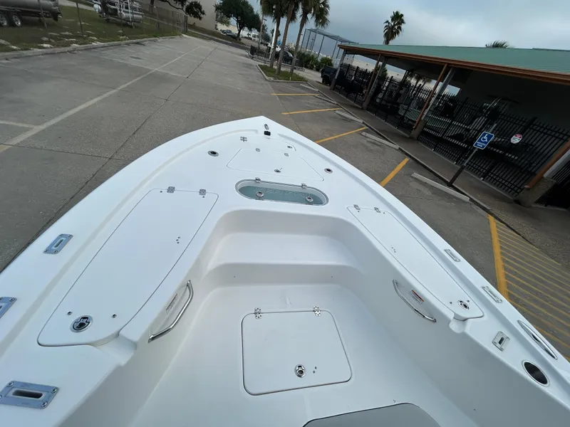 Slide: The Image of 2024 Sea Pro 250 DLX boat, spacious deck, parked outdoors. - 21