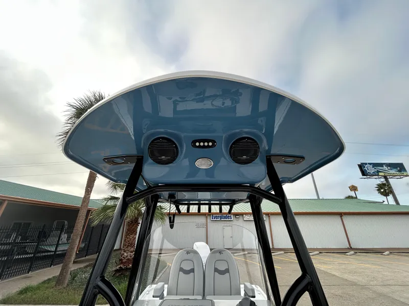 Slide: The Image of 2024 Sea Pro 250 DLX boat with blue T-top and dual speakers. - 24