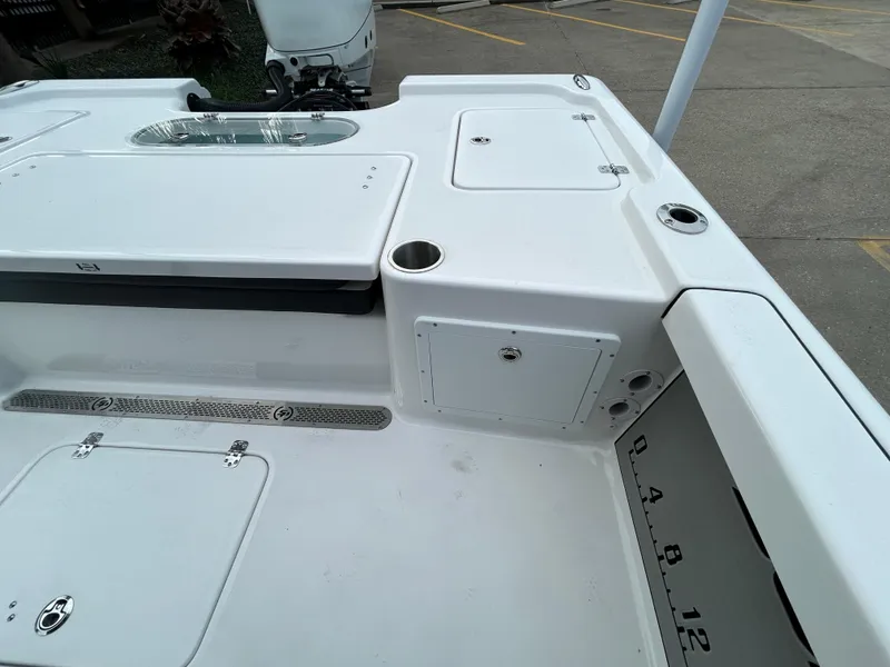 Slide: The Image of 2024 Sea Pro 250 DLX boat deck with storage compartments and cup holders. - 9