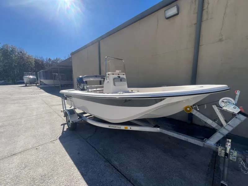 Slide: The Image of 2025 Carolina Skiff E 16 JVX boat on trailer, parked outdoors. - 0