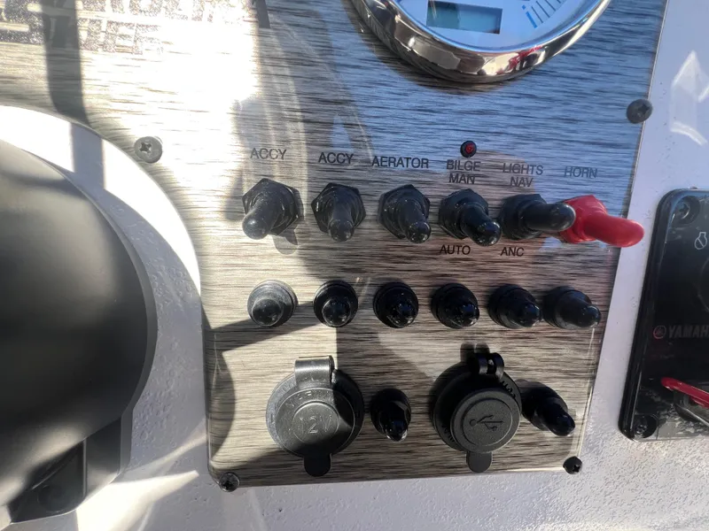 Slide: The Image of Control panel of 2025 Carolina Skiff E 16 JVX boat with switches and gauges. - 10