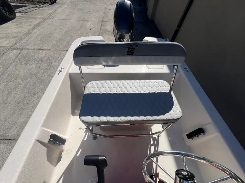 Slide: The Image of 2025 Carolina Skiff E 16 JVX boat interior with steering wheel and cushioned seat. - 13