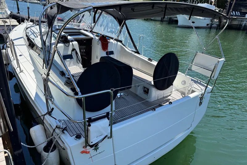 Slide: The Image of 2025 Jeanneau Sun Odyssey 350 sailboat docked in marina, featuring spacious cockpit and canopy. - 25