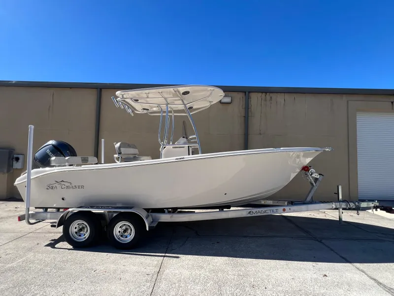 The Image of 2025 Sea Chaser 22 HFC boat on trailer, parked outdoors under clear blue sky. - 1