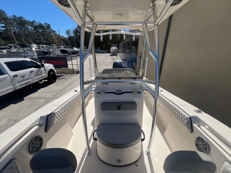 Slide: The Image of 2025 Sea Chaser 22 HFC boat interior with seating and console, parked outdoors. - 21