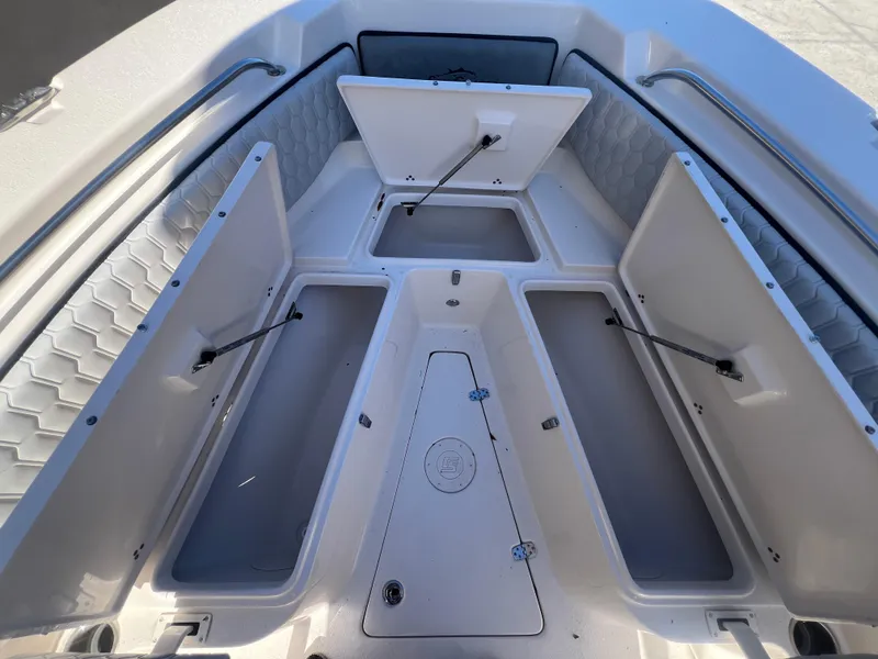 Slide: The Image of 2025 Sea Chaser 22 HFC boat with open storage compartments and cushioned seating. - 23