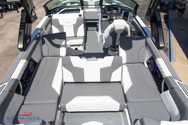 Slide: The Image of 2024 MasterCraft NXT24 boat interior with gray and white seating, spacious layout. - 17