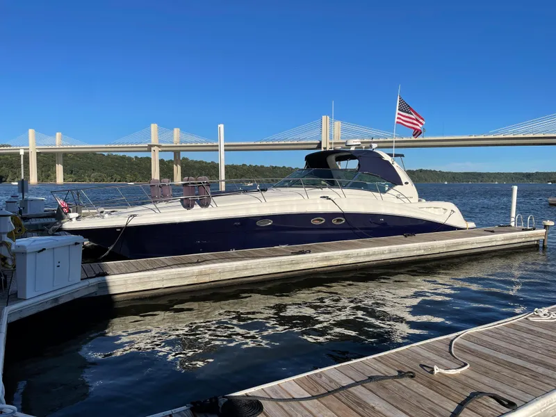 The Image of 2003 Sea Ray 420 Sundancer yacht docked by a bridge on a sunny day. - 0