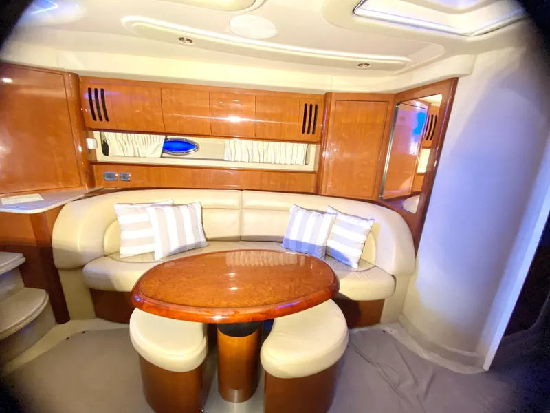 Slide: The Image of 2003 Sea Ray 420 Sundancer interior with curved seating and wooden table. - 22