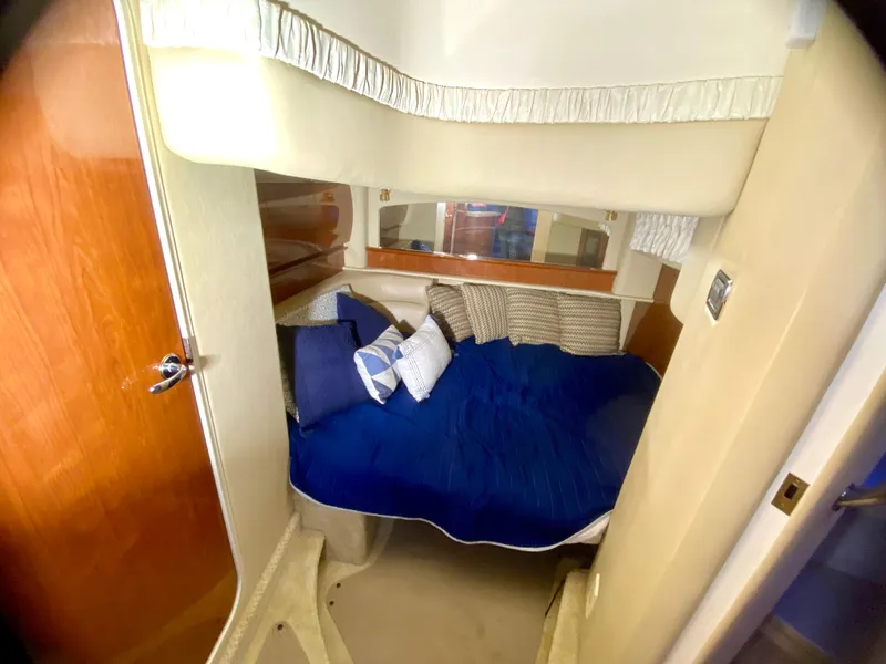 Slide: The Image of 2003 Sea Ray 420 Sundancer cabin with cozy bed and blue bedding. - 23