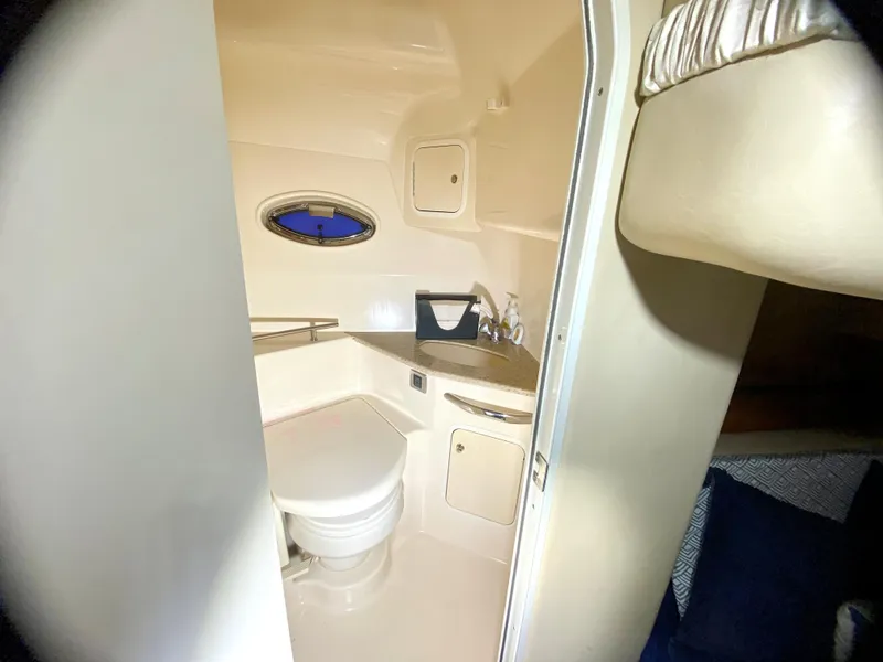Slide: The Image of 2003 Sea Ray 420 Sundancer bathroom interior with toilet, sink, and porthole window. - 25