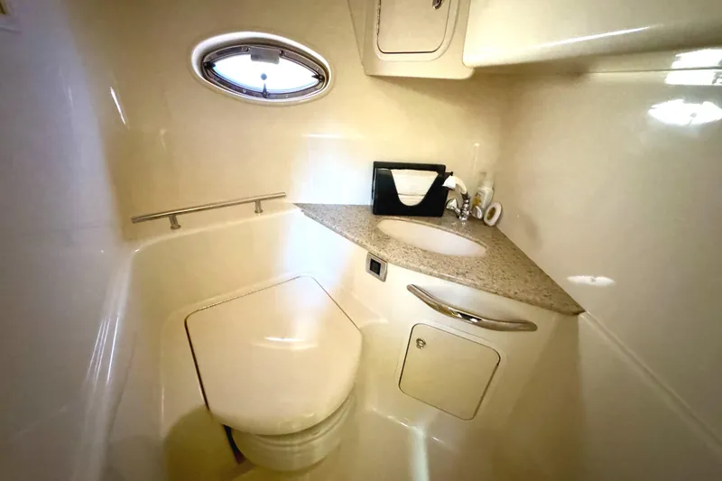 Slide: The Image of 2003 Sea Ray 420 Sundancer bathroom with sink, toilet, and porthole window. - 26