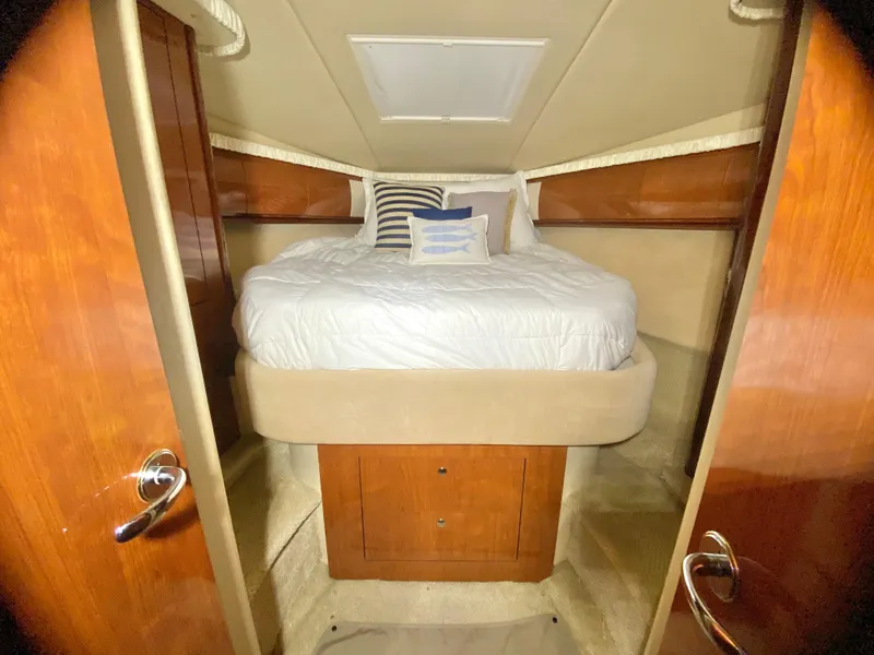 Slide: The Image of Luxurious cabin interior of 2003 Sea Ray 420 Sundancer with cozy bed and wooden accents. - 27