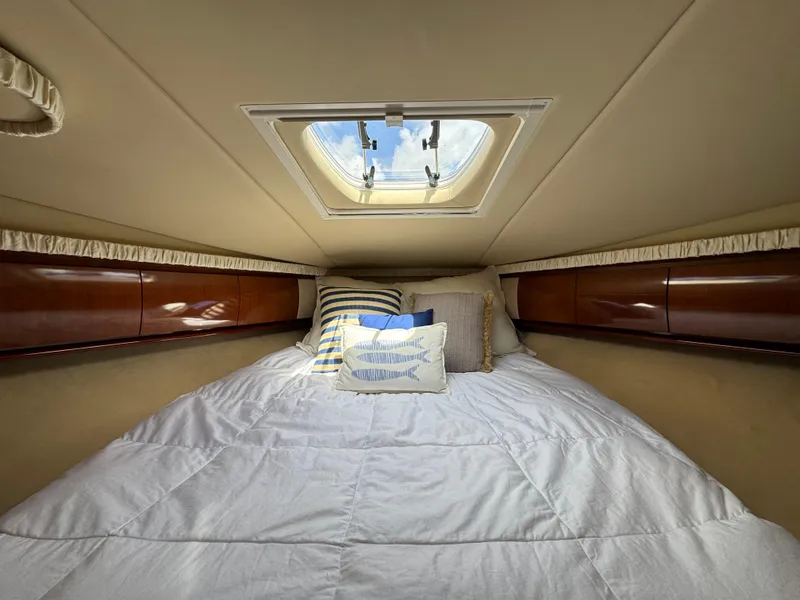 Slide: The Image of Cozy cabin interior of 2003 Sea Ray 420 Sundancer with skylight and plush bedding. - 29