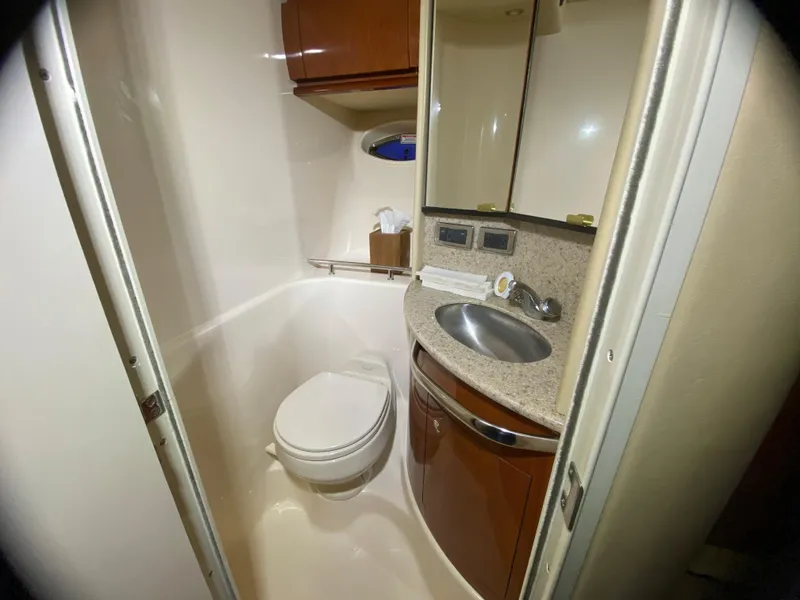 Slide: The Image of 2003 Sea Ray 420 Sundancer bathroom with toilet, sink, and storage cabinets. - 30