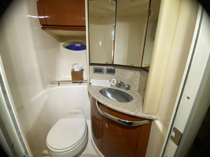Slide: The Image of 2003 Sea Ray 420 Sundancer bathroom with sink, toilet, and mirrored cabinets. - 31