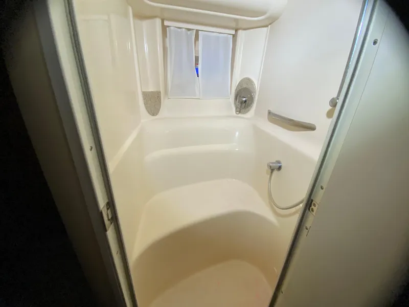 Slide: The Image of Shower area inside 2003 Sea Ray 420 Sundancer yacht, featuring white interior and fixtures. - 32