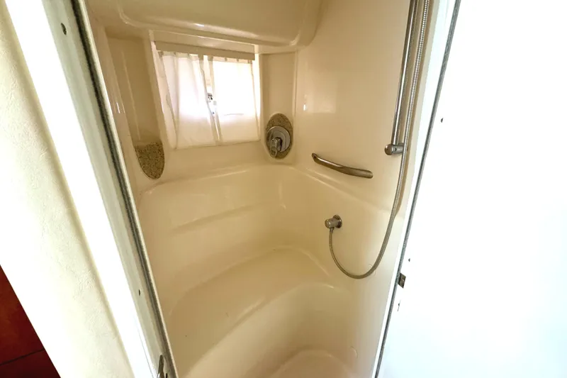 Slide: The Image of 2003 Sea Ray 420 Sundancer shower interior with handheld showerhead and window. - 33