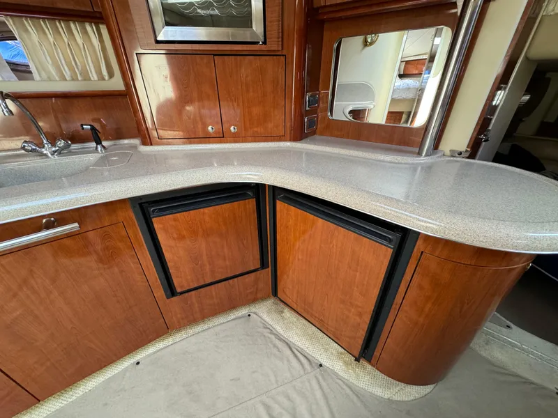 Slide: The Image of 2003 Sea Ray 420 Sundancer kitchen with wood cabinetry and modern appliances. - 34