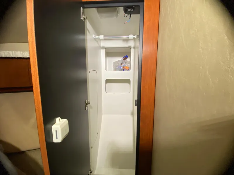 Slide: The Image of Interior closet of 2003 Sea Ray 420 Sundancer yacht, featuring storage shelves and hanging rod. - 38