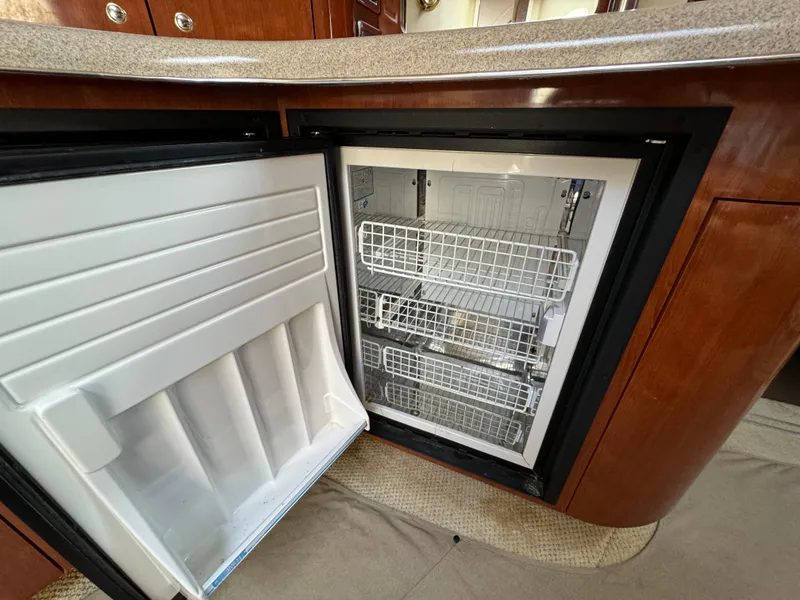 Slide: The Image of Open refrigerator in 2003 Sea Ray 420 Sundancer yacht, showcasing interior storage baskets. - 43