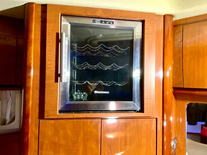 Slide: The Image of Wine cooler in 2003 Sea Ray 420 Sundancer yacht interior, featuring wooden cabinetry. - 44