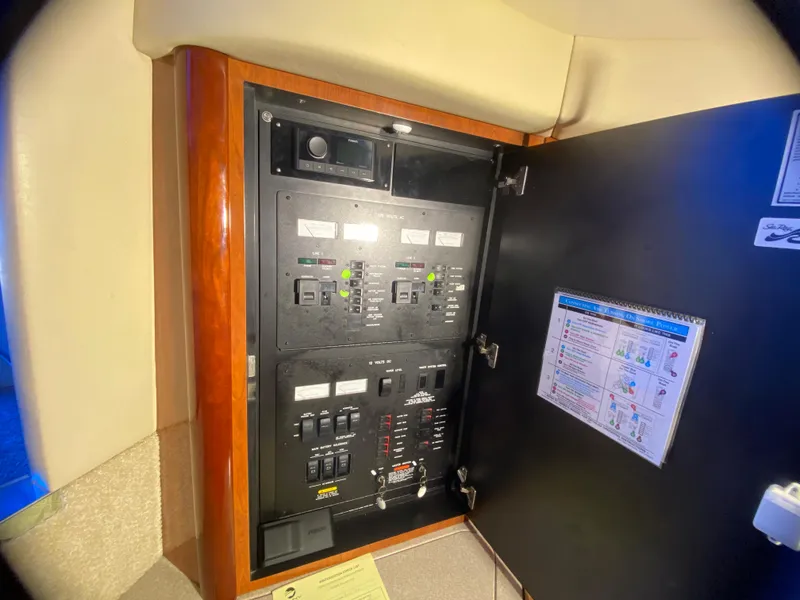 Slide: The Image of Electrical panel inside 2003 Sea Ray 420 Sundancer yacht, featuring control switches and instructions. - 46