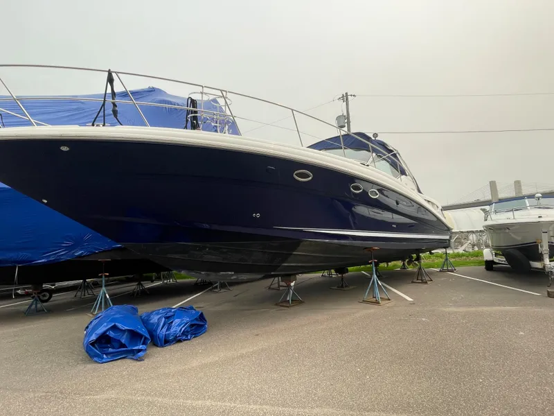 Slide: The Image of 2003 Sea Ray 420 Sundancer yacht on stands, blue hull, parked outdoors. - 5