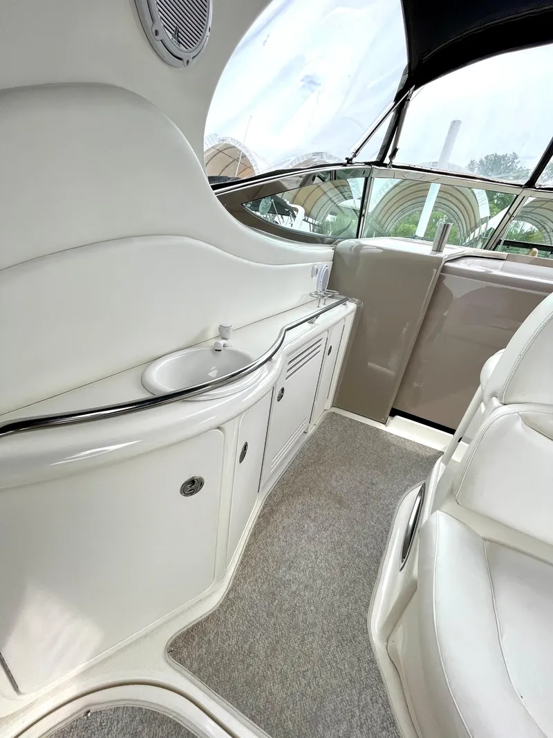 Slide: The Image of Interior of 2003 Sea Ray 420 Sundancer yacht, featuring sleek white cabinetry and seating. - 9