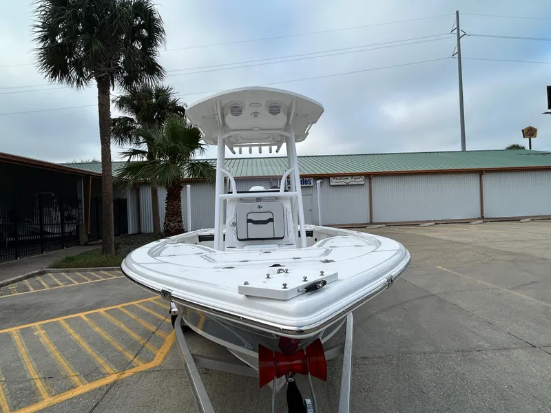 Slide: The Image of 2025 Sea Pro 210 Bay boat in a parking lot, front view with palm trees. - 2