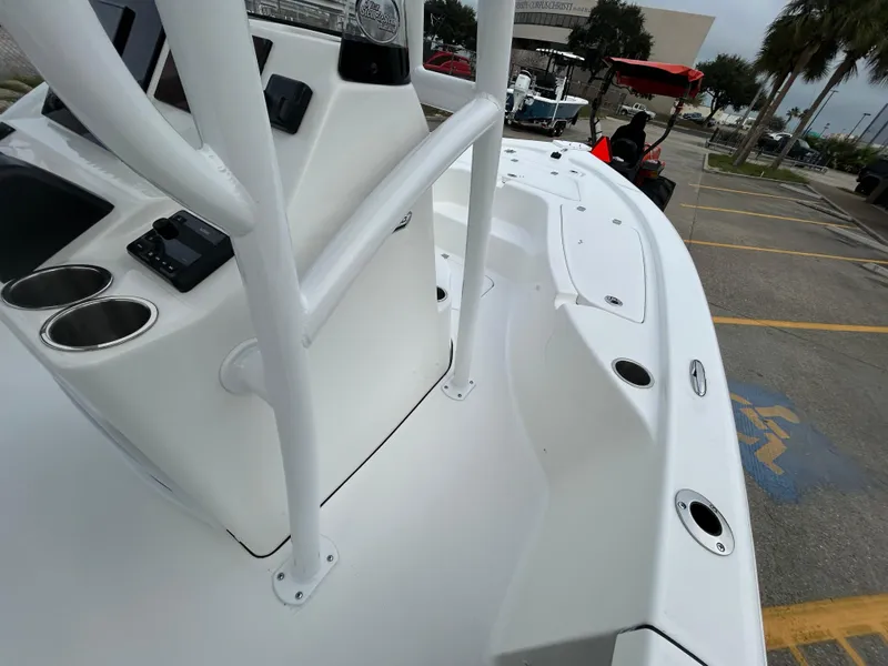 Slide: The Image of 2025 Sea Pro 210 Bay boat, white deck, console with cup holders, parked outdoors. - 7