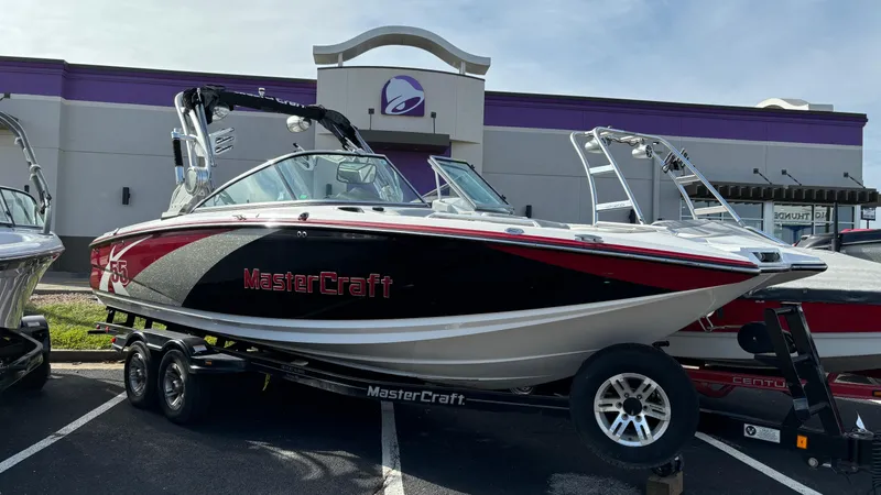 The Image of 2013 MasterCraft X55 boat on trailer in parking lot. - 0