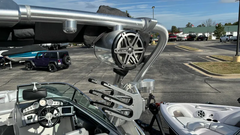 Slide: The Image of 2013 MasterCraft X55 boat with wakeboard tower and speakers in a parking lot. - 11