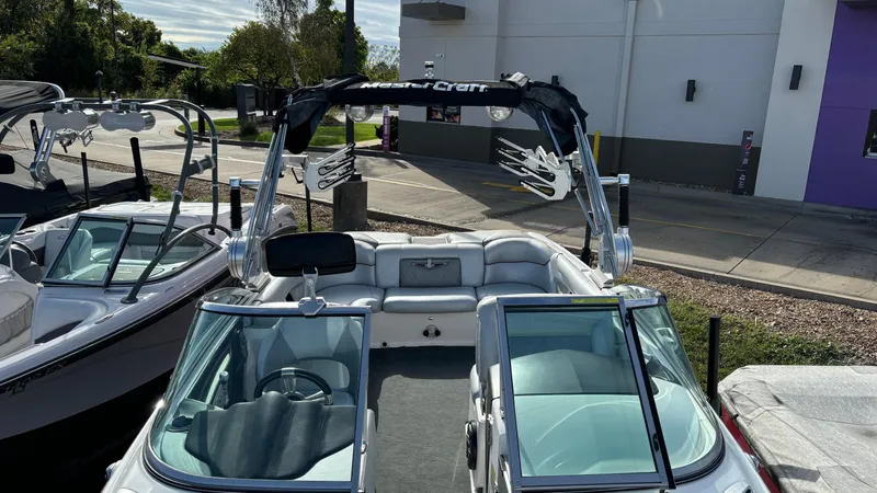 Slide: The Image of 2013 MasterCraft X55 boat with sleek design and spacious interior, parked outdoors. - 19