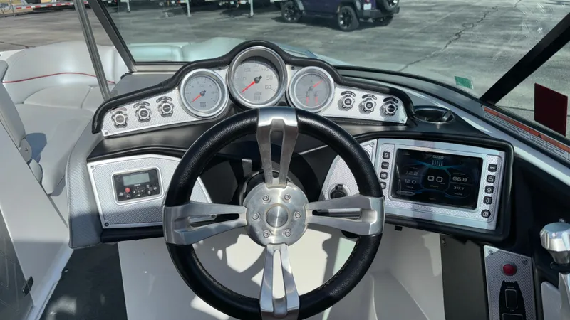 Slide: The Image of 2013 MasterCraft X55 boat dashboard with steering wheel and gauges. - 33