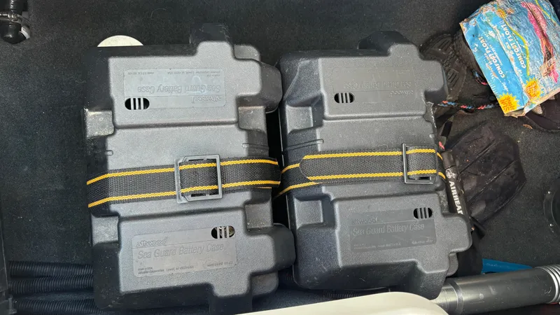Slide: The Image of Two secured battery boxes in a 2013 MasterCraft X55 boat compartment. - 47
