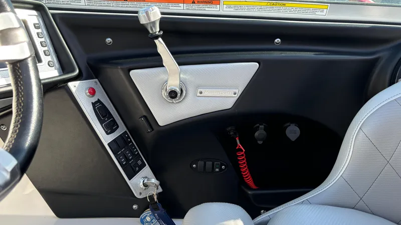 Slide: The Image of Interior controls of a 2013 MasterCraft X55 boat, featuring steering and dashboard elements. - 49