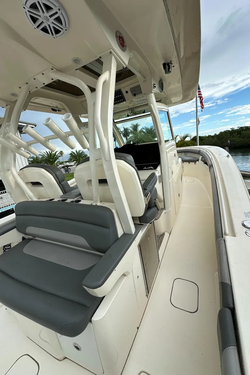 Slide: The Image of 2017 Scout 350 LXF boat interior with seating and helm, docked by water. - 17
