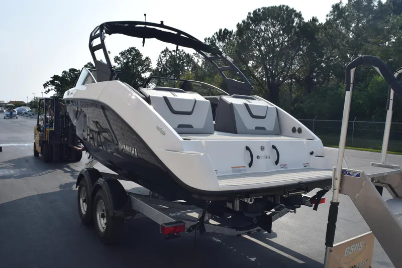 Slide: The Image of 2025 Yamaha Boats AR220 on trailer, rear view, parked outdoors. - 4
