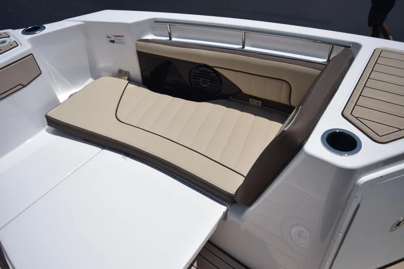 Slide: The Image of 2025 Yamaha Boats 255 FSH Sport E interior seating with beige upholstery and cup holder. - 13