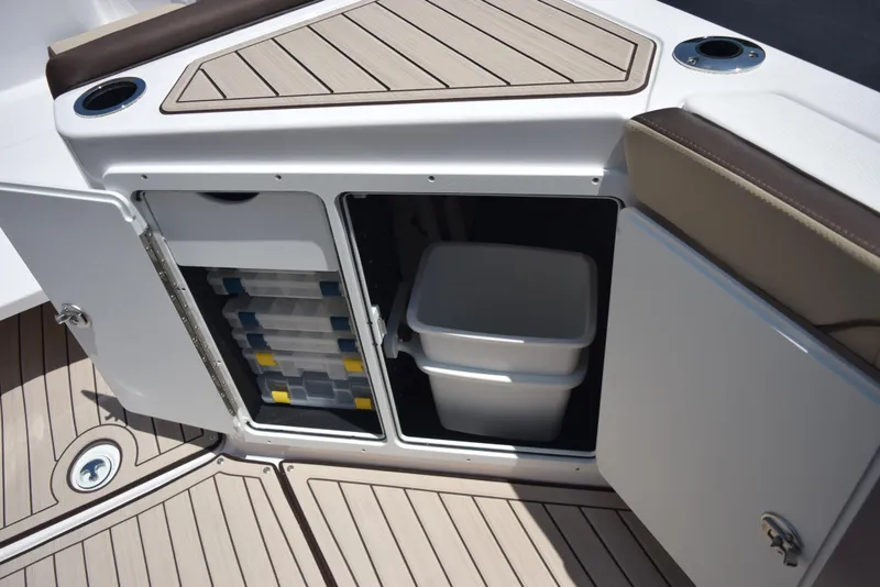 Slide: The Image of 2025 Yamaha Boats 255 FSH Sport E storage compartment with tackle boxes and cooler. - 15